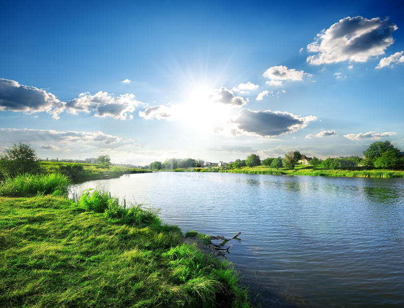 Sun over calm river in the spring morning